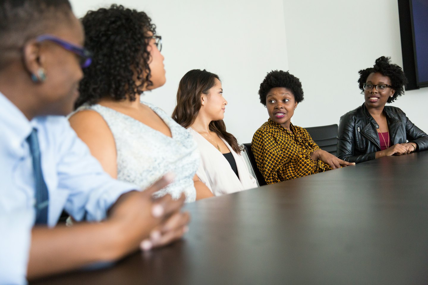 Diverse professionals collaborate around a conference table during a meeting.